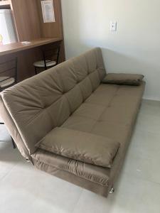 a brown couch sitting in a living room at Studio J&C 01 in Primavera do Leste