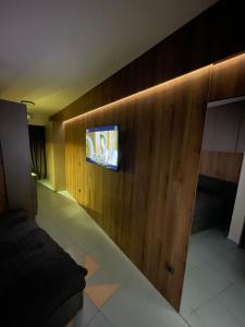 a living room with a tv on a wooden wall at Studio Luxe in Kampor