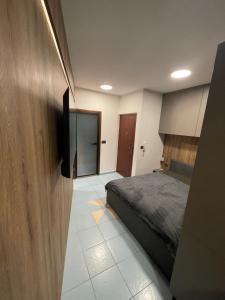 a bedroom with a bed and a flat screen tv at Studio Luxe in Kampor