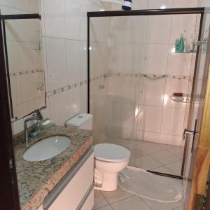 a bathroom with a toilet and a sink and a shower at Quarto aconchegante in Curitiba