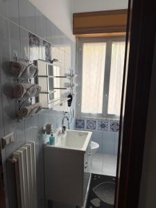 a bathroom with a white sink and a window at Carmen House in Bernalda