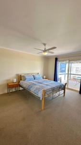 a bedroom with a bed and a ceiling fan at Catch N Relax in Point Turton