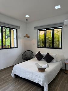 a bedroom with a large white bed with windows at Casa Del Río in Montería +61 photos