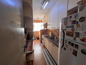 a kitchen with a white refrigerator and a sink at Ap decorado Setor Bueno in Água Boa