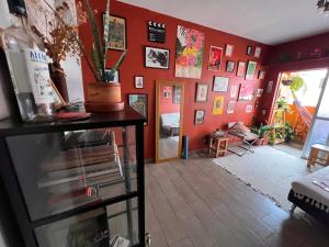 a living room with a red wall with pictures at Ap decorado Setor Bueno in Água Boa