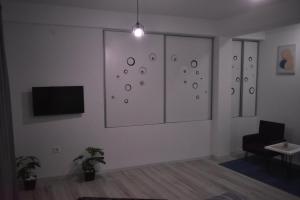 ein Wohnzimmer mit Fernseher und Sessel in der Unterkunft Cavdarov in Štip