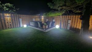 a backyard at night with a fence with lights at W Ustce Lipa in Ustka