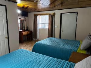 a bedroom with two beds and a desk and a window at hotel Rarámuri in Creel +12 photos