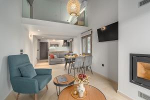 a living room with a blue chair and a table at Harmony Apartments in Agioi Apostoli