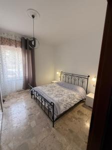 a bedroom with a bed in a room with a window at Carmen House in Bernalda
