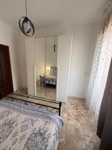 a bedroom with a bed and a mirror at Carmen House in Bernalda