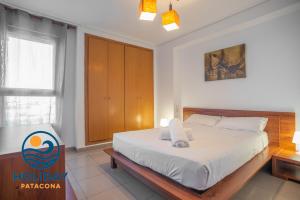 a bedroom with a bed and a wooden cabinet at Holiday Apartment Patacona Beach in Valencia +18 photos