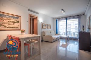 a living room with a table and a couch at Holiday Apartment Patacona Beach in Valencia