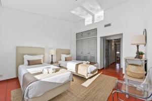 a bedroom with two beds and a chair at Casa Mimosa by Algarve Holidays in Vale do Lobo +27 photos