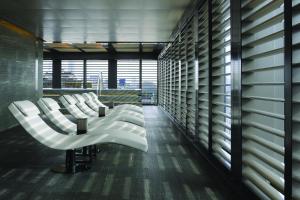 a row of white chairs in a room with a window at Armani Hotel Milano in Milan