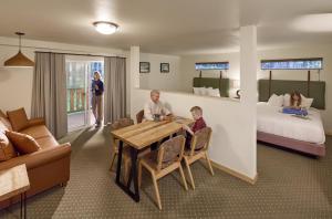 two children sitting at a table in a hotel room at Seward Windsong Lodge in Seward