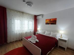 a bedroom with a large bed with a red blanket at Pensiunea CARLA in Sărata-Monteoru