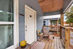 a porch with a white door and a chair at Gil's Bayou Cabins in Ocean Springs