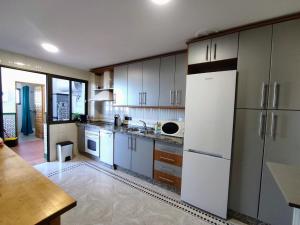 a kitchen with white cabinets and a white refrigerator at Casas Medina Güevéjar in Güevéjar