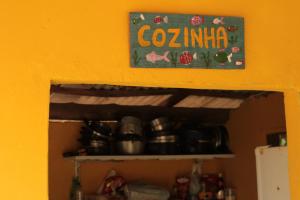 a shelf with a sign that says coculum on a wall at Cabana 2 Camping Dona Aurora Praia do Sono in Paraty