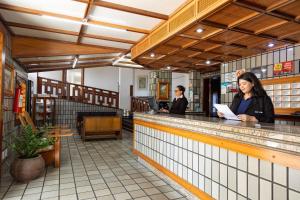 two women standing at the counter of a restaurant at Shalako Hotel in Vitória da Conquista