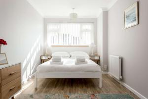 a white bedroom with a bed and a window at Reel Time - Beautiful Townhouse a Stone's Throw from Poole Quay in Poole +30 photos