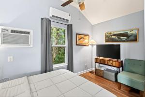 a bedroom with a bed and a tv and a chair at Gil's Bayou Cabins in Ocean Springs