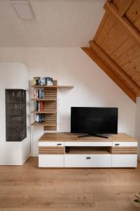 a living room with a flat screen tv on a cabinet at Haus am Südfrüchtegarten in Rhodt unter Rietburg