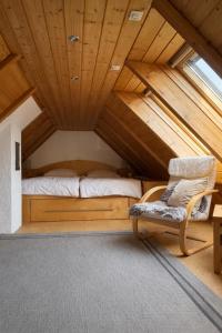a bedroom with a bed and a chair in a attic at Haus am Südfrüchtegarten in Rhodt unter Rietburg
