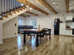 a kitchen and dining room with a table and chairs at Domek NAD RZEKA in Korczew