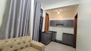 a living room with a couch and a kitchen at VEGAS Motel in Kigali
