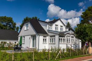 a white house with a black roof at Mühlenhaus Tretmühle in Prerow