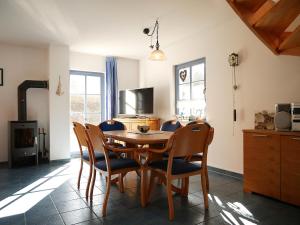 a dining room with a wooden table and chairs at Fini in Am Schwarzen Busch +16 photos
