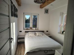 a small bedroom with a bed and a window at Domek NAD RZEKA in Korczew