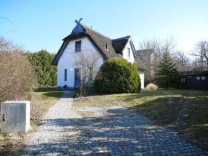 a small white house with a thatched roof at Fini in Am Schwarzen Busch