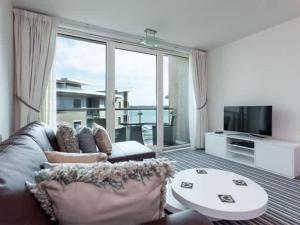 a living room with a couch and a large window at Reflections - Balcony Views of Poole Harbour in Poole +23 photos