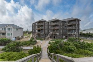 a row of apartment buildings on a beach with a wooden walkway at 7660 - Robyn's Nest in Avon