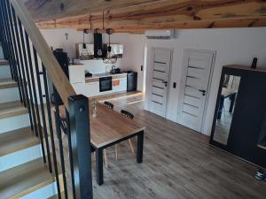a living room with a wooden table and stairs at Domek NAD RZEKA in Korczew