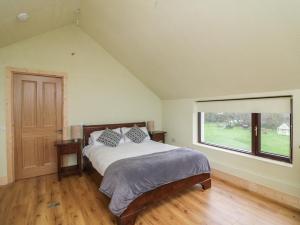 a bedroom with a bed and a large window at The Rookery in Greenfield Cross Roads