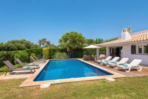a swimming pool with chairs and a house at Villa Sirena - Cap den Font in Binisafua