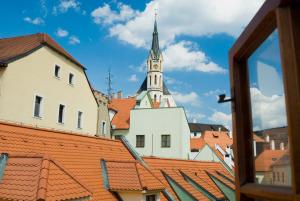 a view of a tall building with a steeple on top of roofs at Penzion Na Louži in Český Krumlov +10 photos