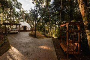 a tent in the woods with a car parked in front at Refúgio Bela Cabanas in Imaruí