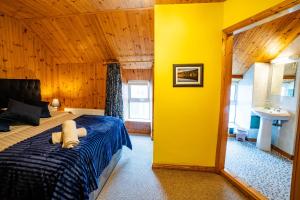 a bedroom with a bed and a yellow wall at The Sheepshead Guesthouse in Durrus