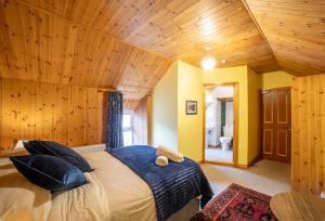 a bedroom with a large bed with a wooden ceiling at The Sheepshead Guesthouse in Durrus