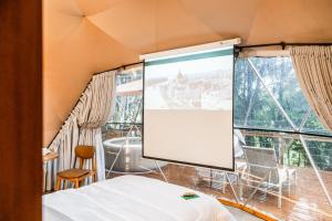 a large screen in a room with a bed at Refúgio Bela Cabanas in Imaruí