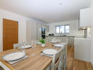 a kitchen and dining room with a wooden table and chairs at Golygfa in Bodorgan