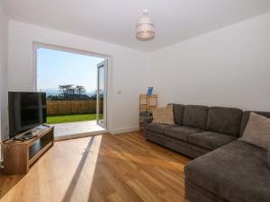 a living room with a couch and a flat screen tv at Golygfa in Bodorgan