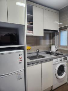 a kitchen with a sink and a washing machine at DASOM in Busan