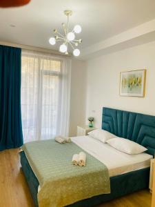 a bedroom with a large bed with a blue headboard at Holidays inkutaisi in Tsqnetʼi