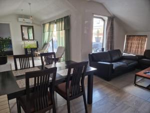 a living room with a table and chairs and a couch at Apartman Gradina in Doboj